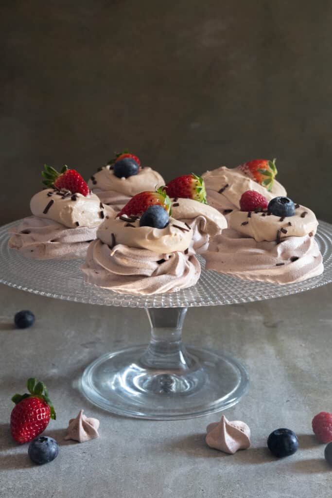 Meringue desserts on a glass cake dish.