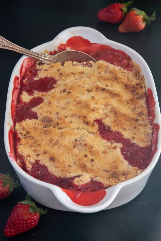 Strawberry crumble in a white dish.
