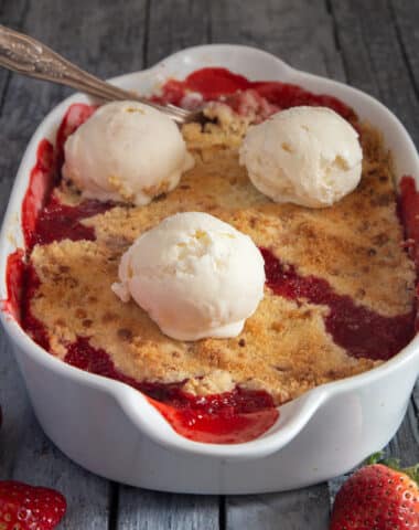 Crumble in a white dish with 3 scoops of ice cream on top.