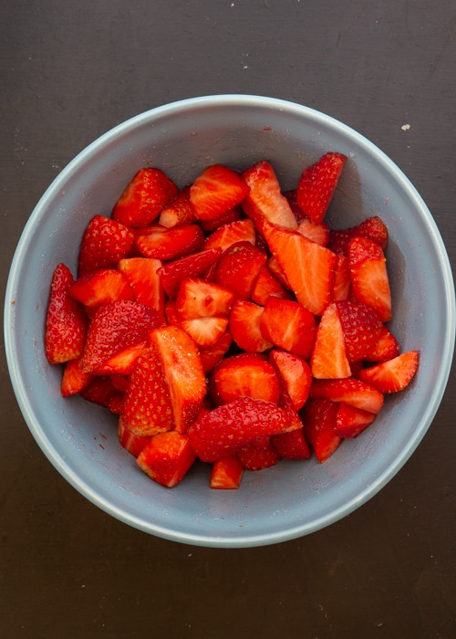 the strawberries chopped in a blue bowl.