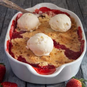 Crumble in a white dish with 3 scoops of ice cream on top.