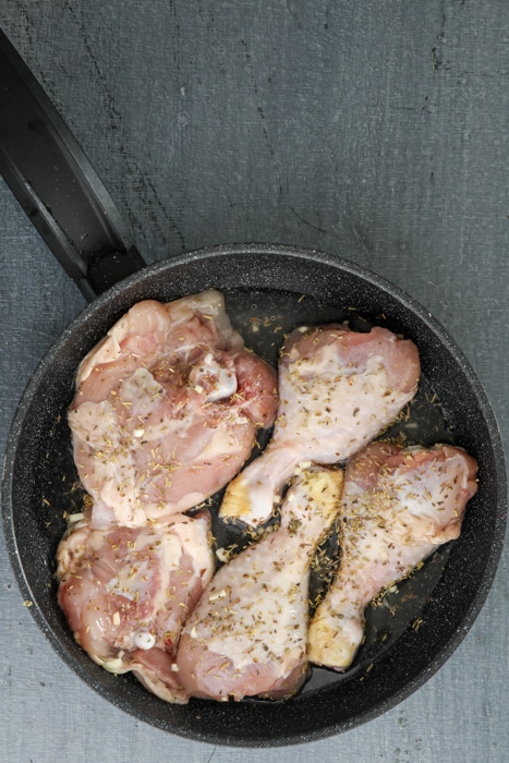 Uncooked chicken in the skillet.