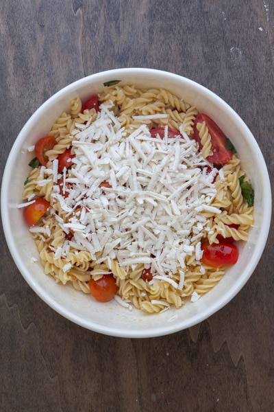 The pasta and cheese added to the ingredients in the bowl.