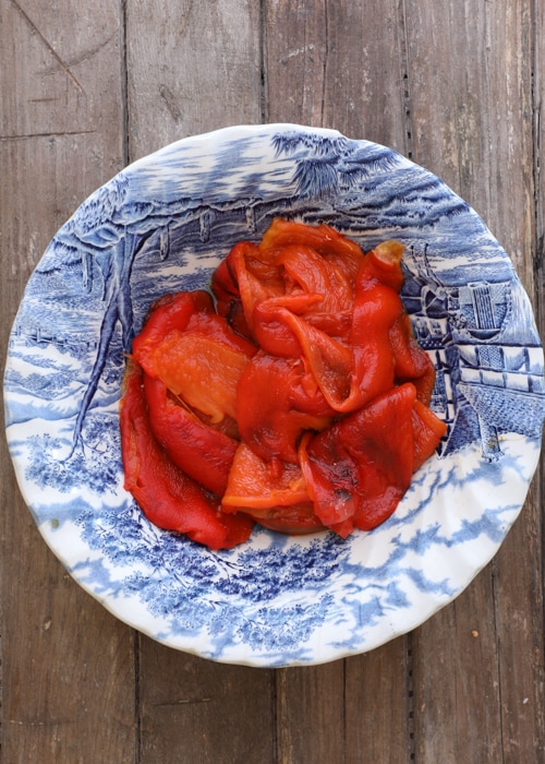 Roasted peppers cleaned and cut in a blue bowl.
