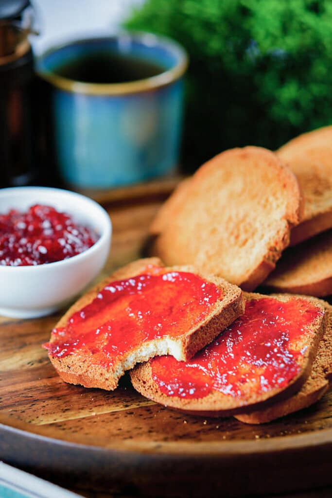 Biscotti on a wooden board with one with a bite out of it.