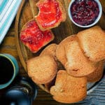 Breakfast biscotti on a wooden board with some jam.