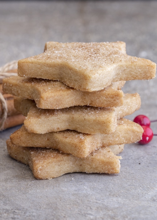 Five cinnamon shortbread cookies shaped as a star stacked.