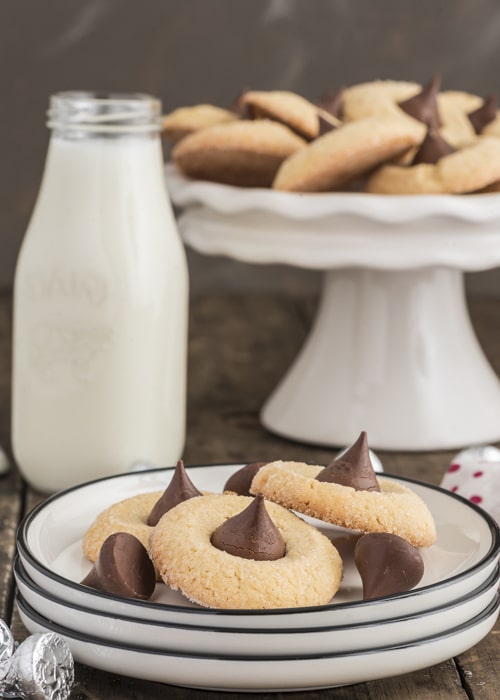 thumbprint cookies on a plate and some on a white cake stand.