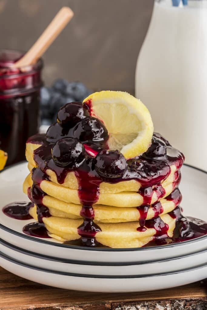 Five stacked lemon ricotta pancakes with blueberry sauce.