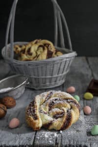 Puff pastry pinwheels in a basket and one on a wooden board.
