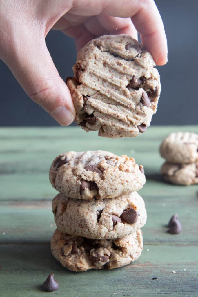 Two cookies stacked and holding another one.