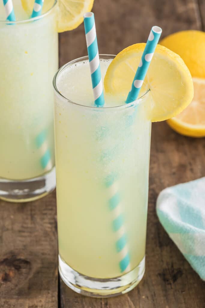 A lemon drink with two straws.