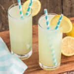 Two glasses of frozen lemonade with blue and white straws.