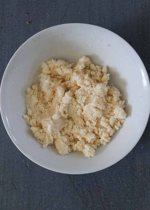 Mixing the egg whites and parmesan cheese in a white bowl.