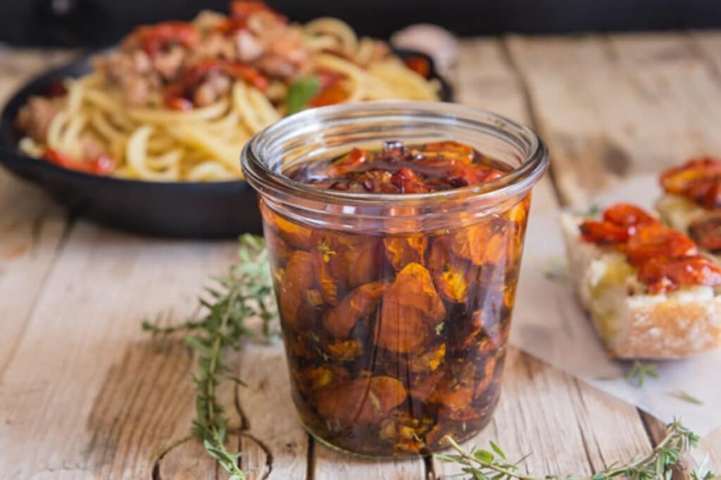 Candied tomatoes in a glass jar.