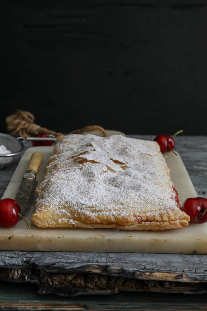 Cherry strudel on a marble board.