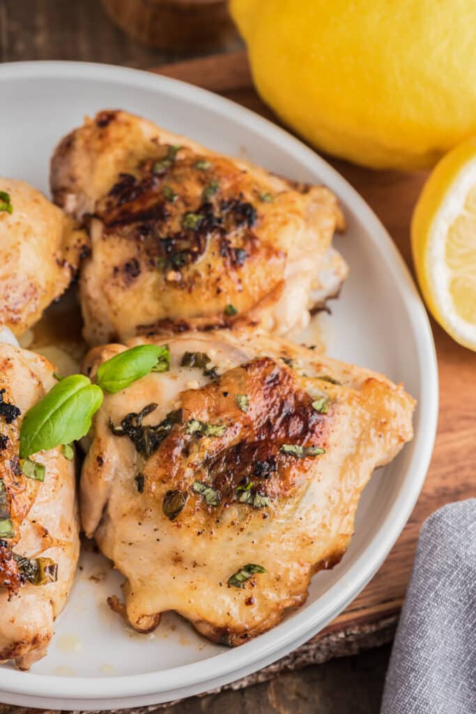 Chicken with basil on a white plate.