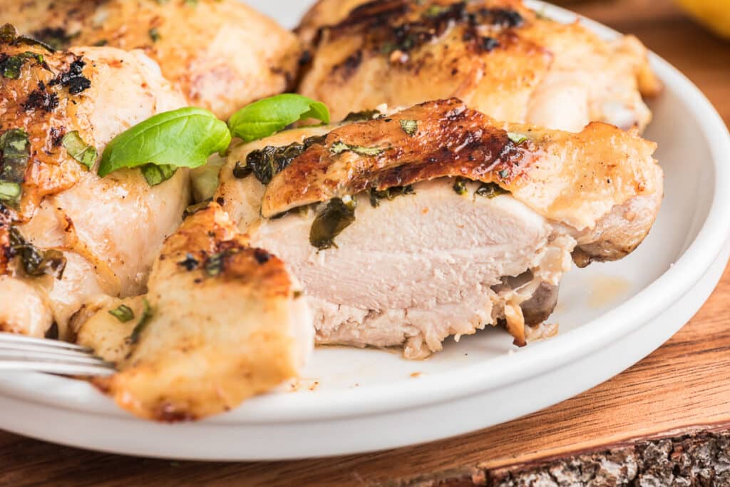 Basil Chicken with a slice cut on a white plate.