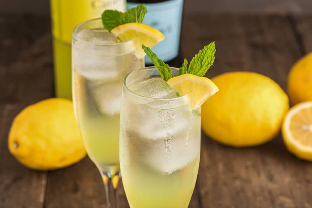 Two cocktails on a wooden board.