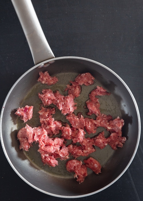 Browning the sausage in a pan.