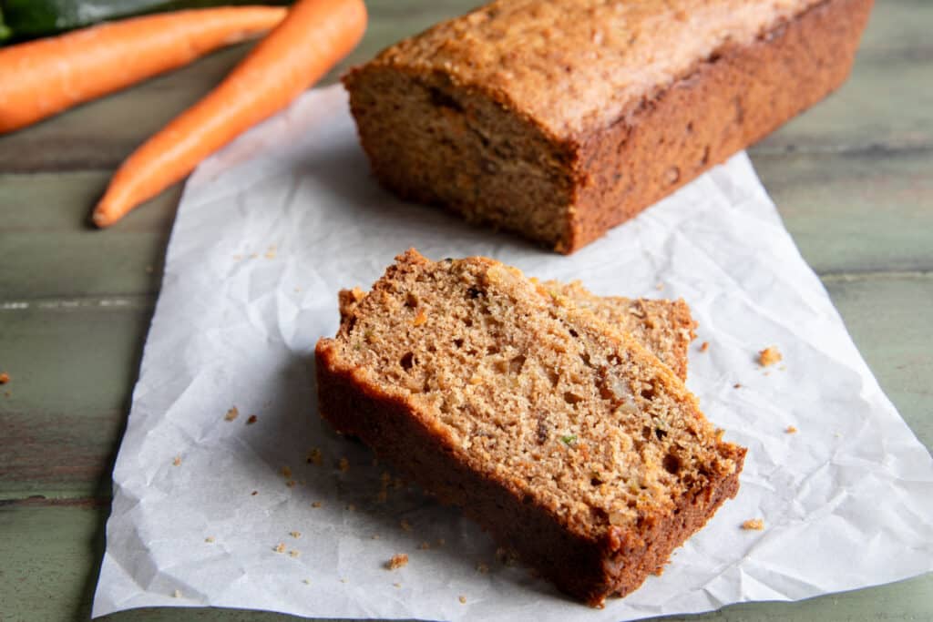 Two slices of zucchini carrot bread on parchment paper.