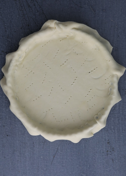 Lining the pan with pastry dough.