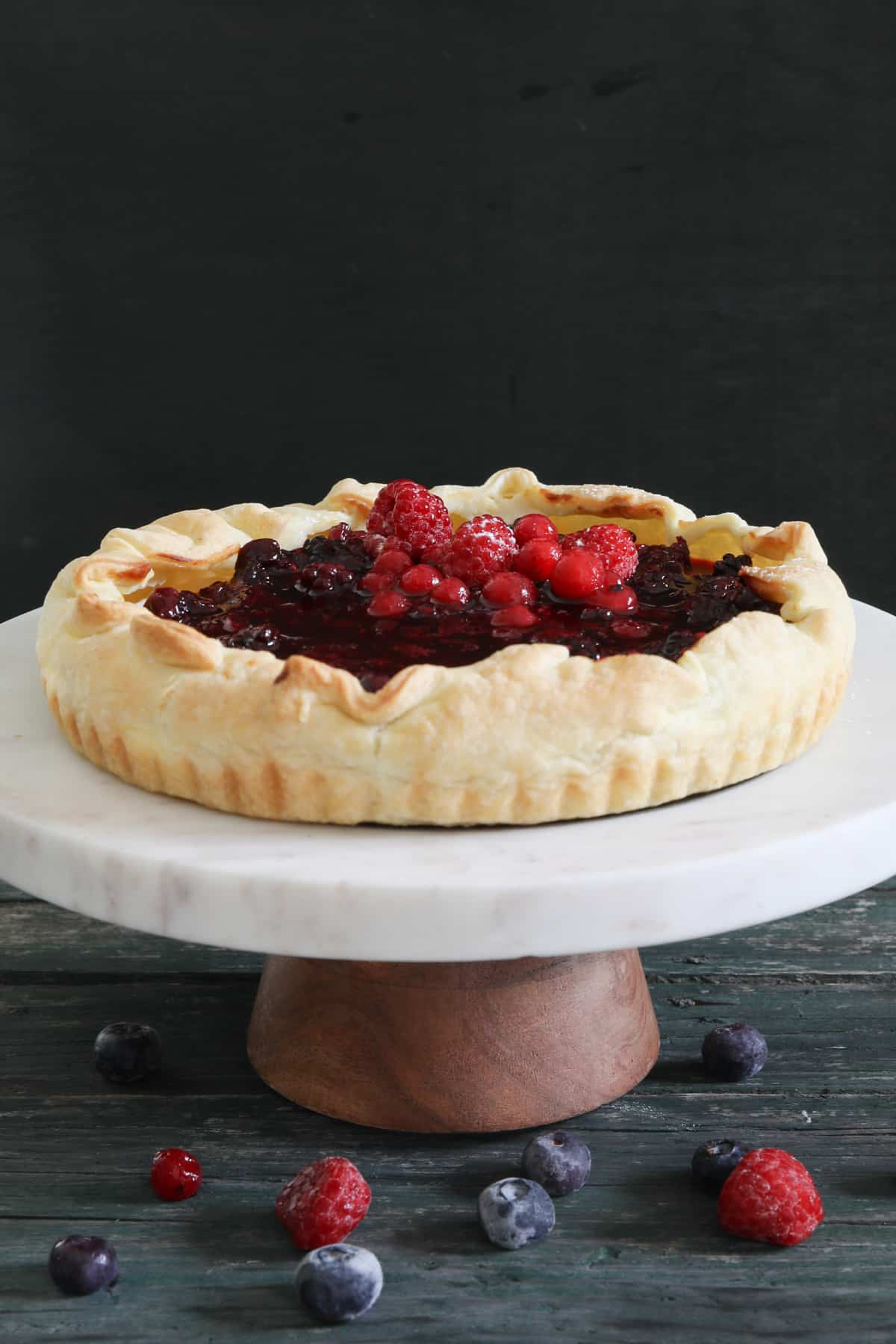 Ricotta crostata on a white cake stand.