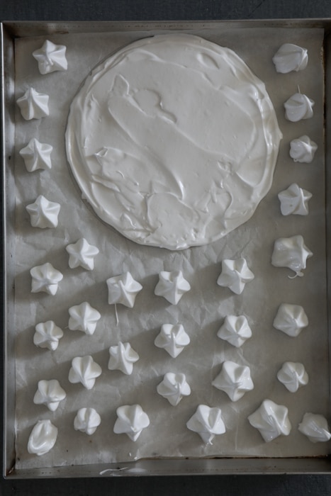 Piping the meringue on the prepared baking sheet.