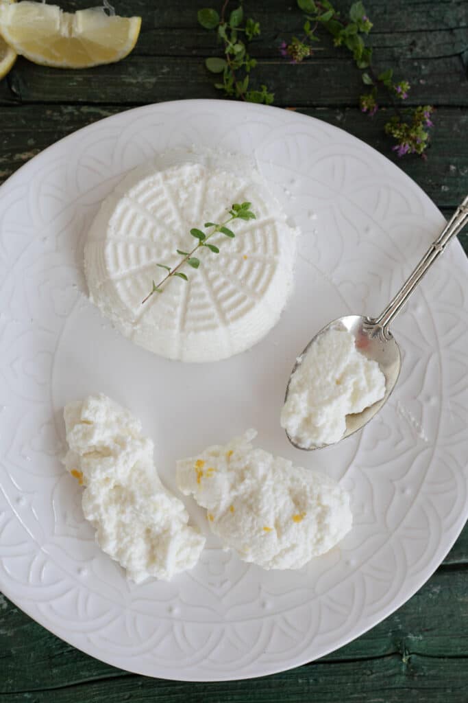 Ricotta on a plate with some on a spoon.