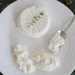 Ricotta on a plate with some on a spoon.