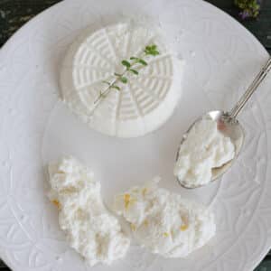 Ricotta on a plate with some on a spoon.