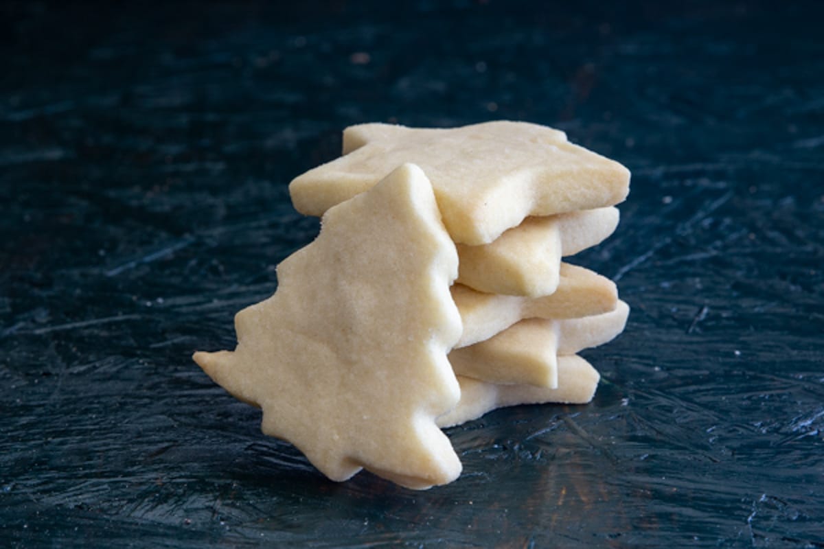 Five shortbread cookies stacked with one leaning against them.