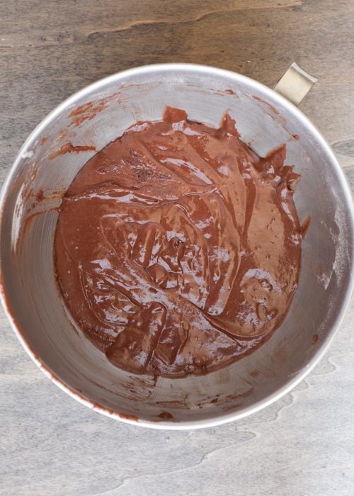 The cake batter mixed in a silver mixing bowl.