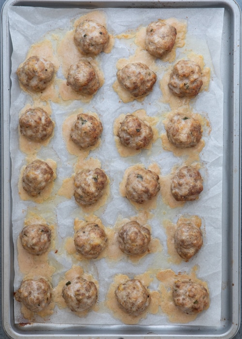 The baked meatballs on the baking sheet.