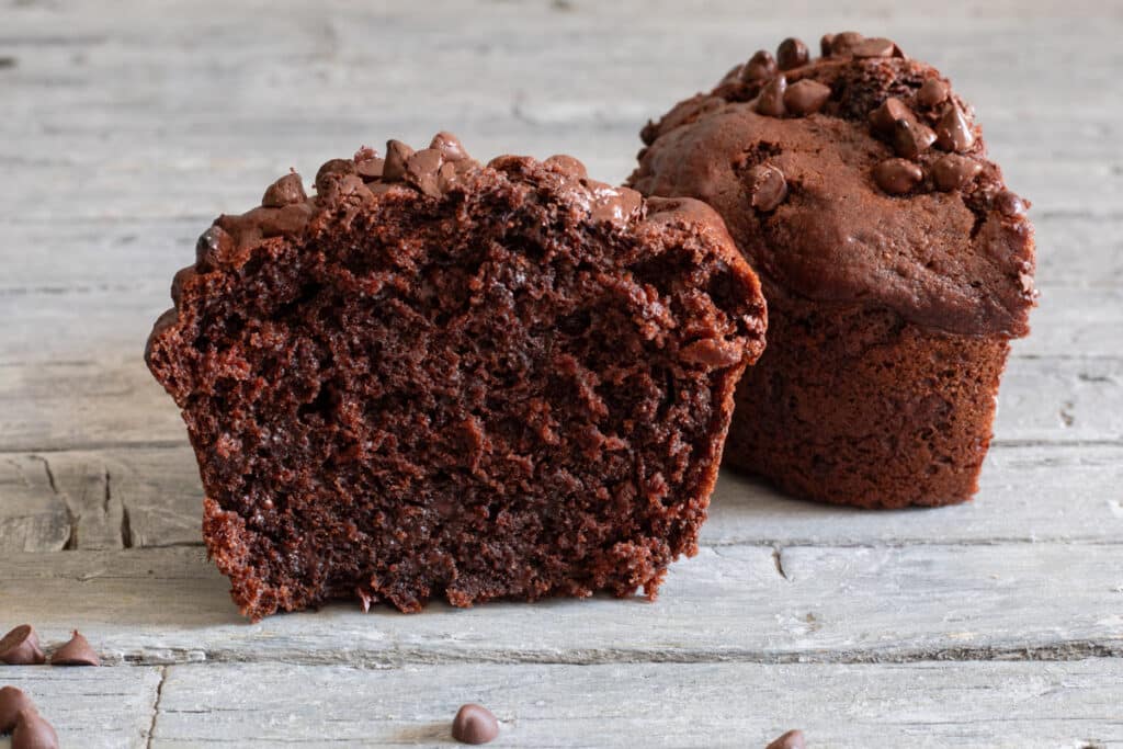 Muffin cut in half on a blue board.