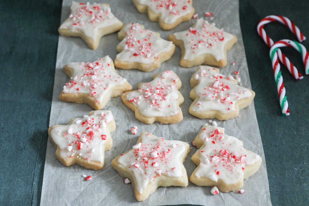 Frosted shortbread cookies on a piece of parchment paper.