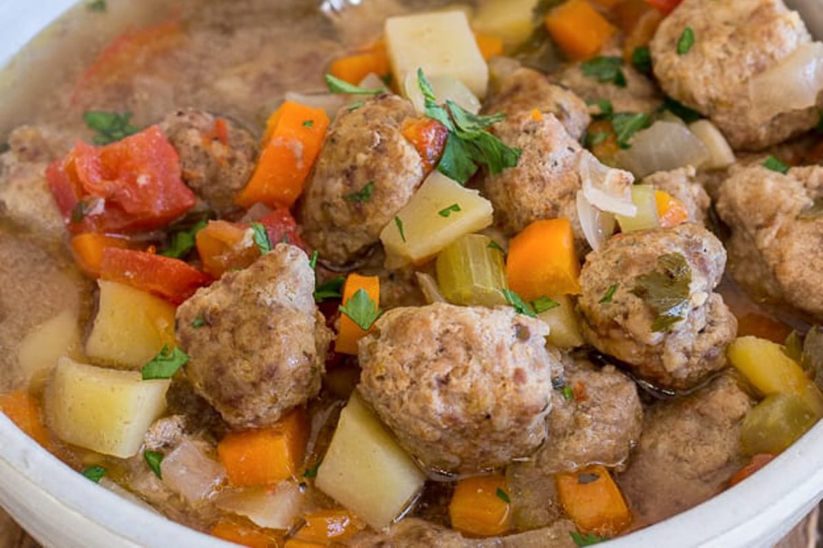 Meatball soup in a white bowl.