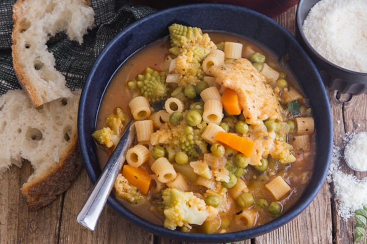 Minestrone soup in a blue bowl.