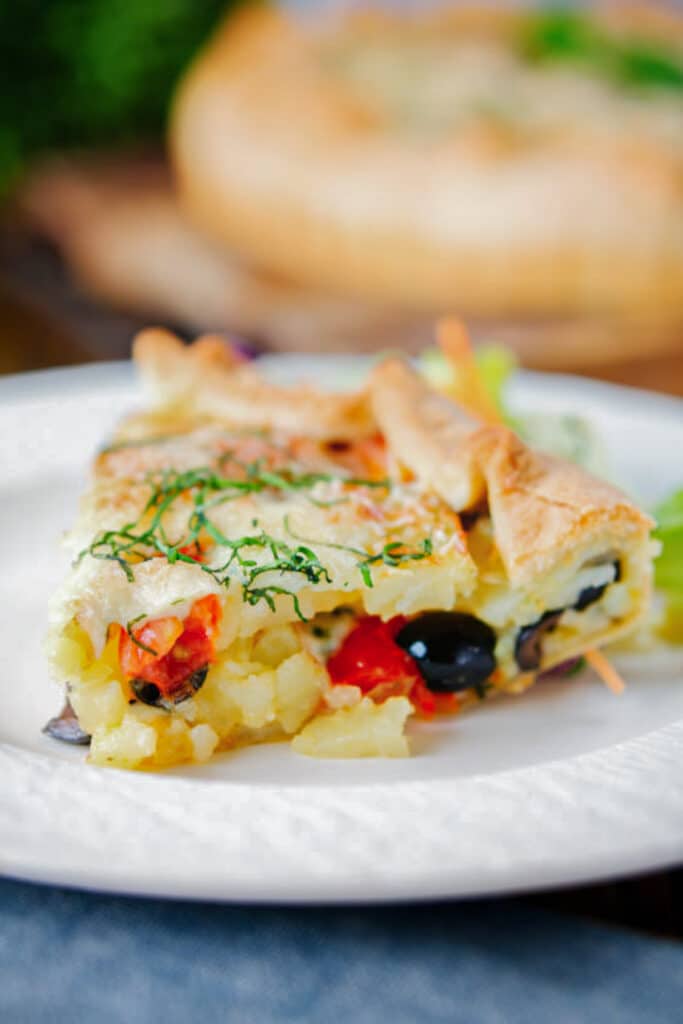 A slice of potato pie on a white plate.