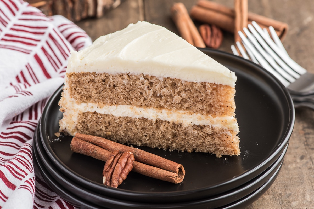 A slice of spice cake on a black plate.