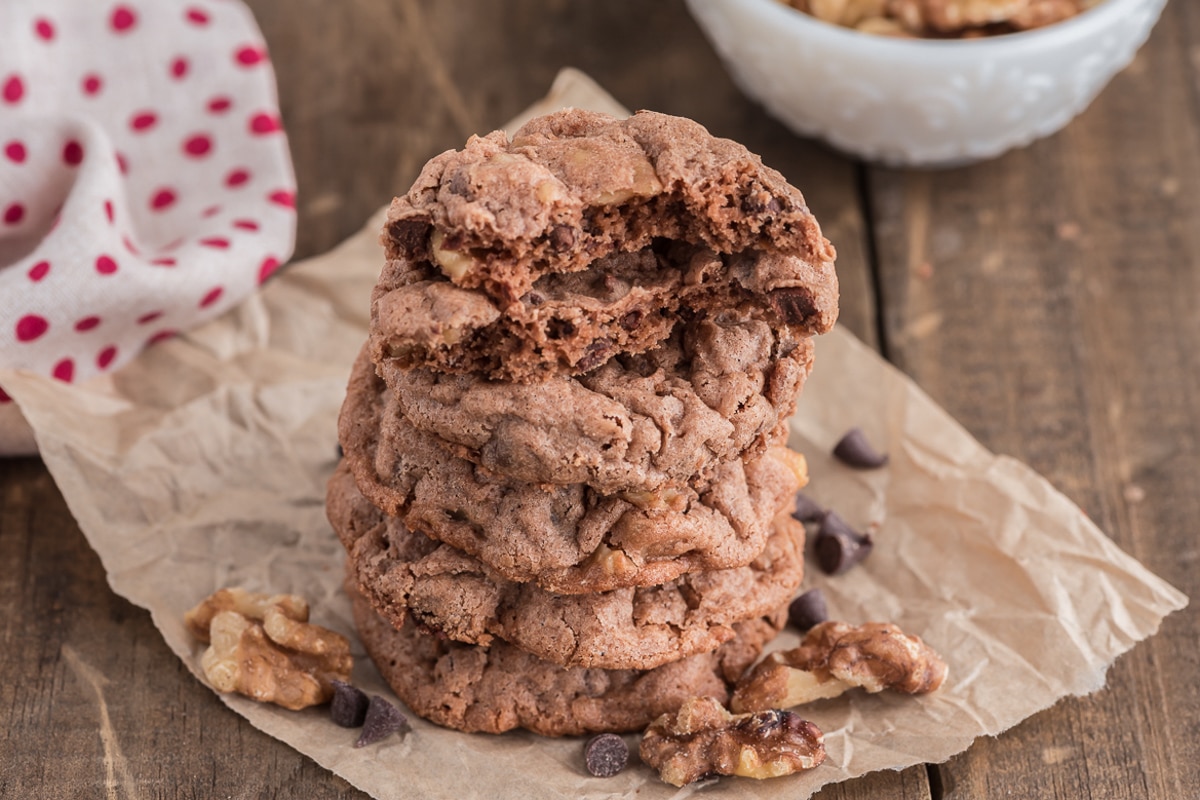 Walnut cookies stacked with one cut in half.