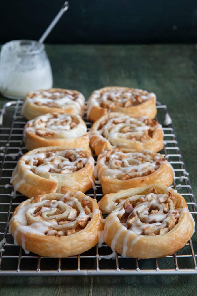 Apple cinnamon roll ups on a wire rack.