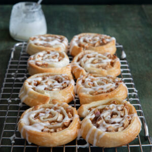 Apple cinnamon roll ups on a wire rack.