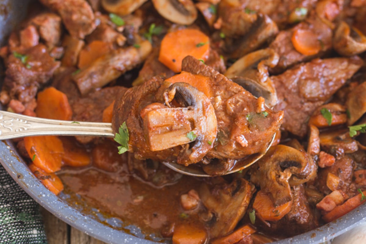 Beef and mushroom stew in a black pan.