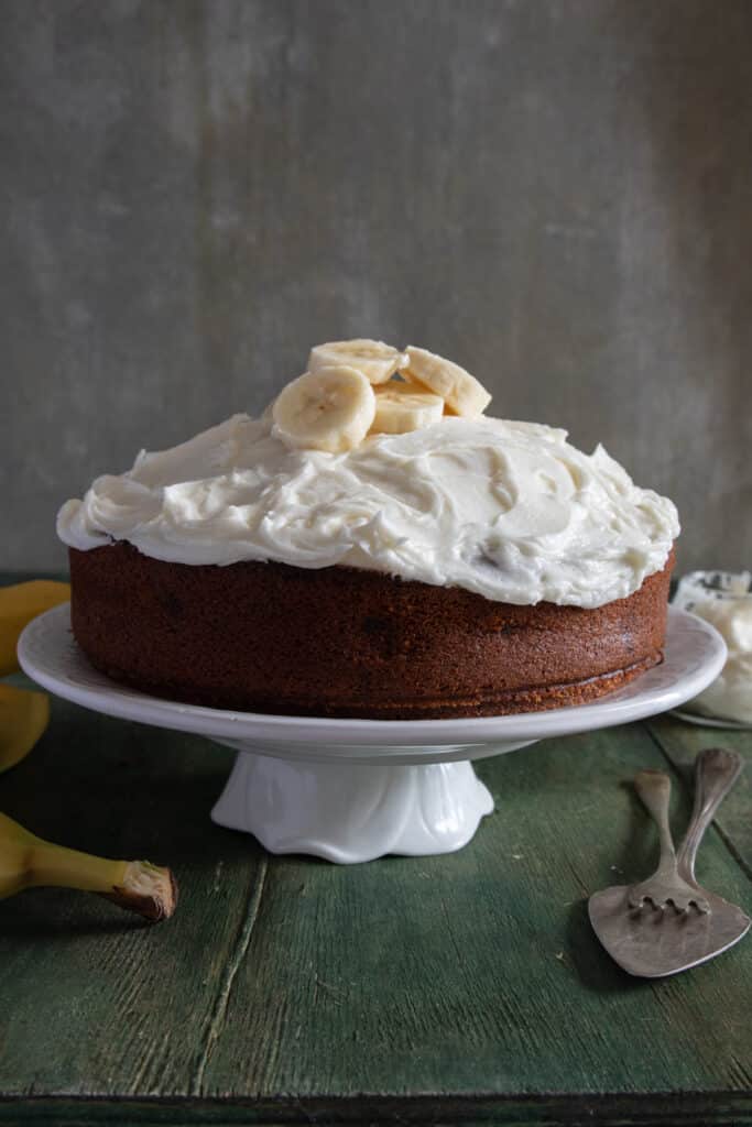 Banana cake on a white cake stand.