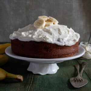 Banana cake on a white cake stand.