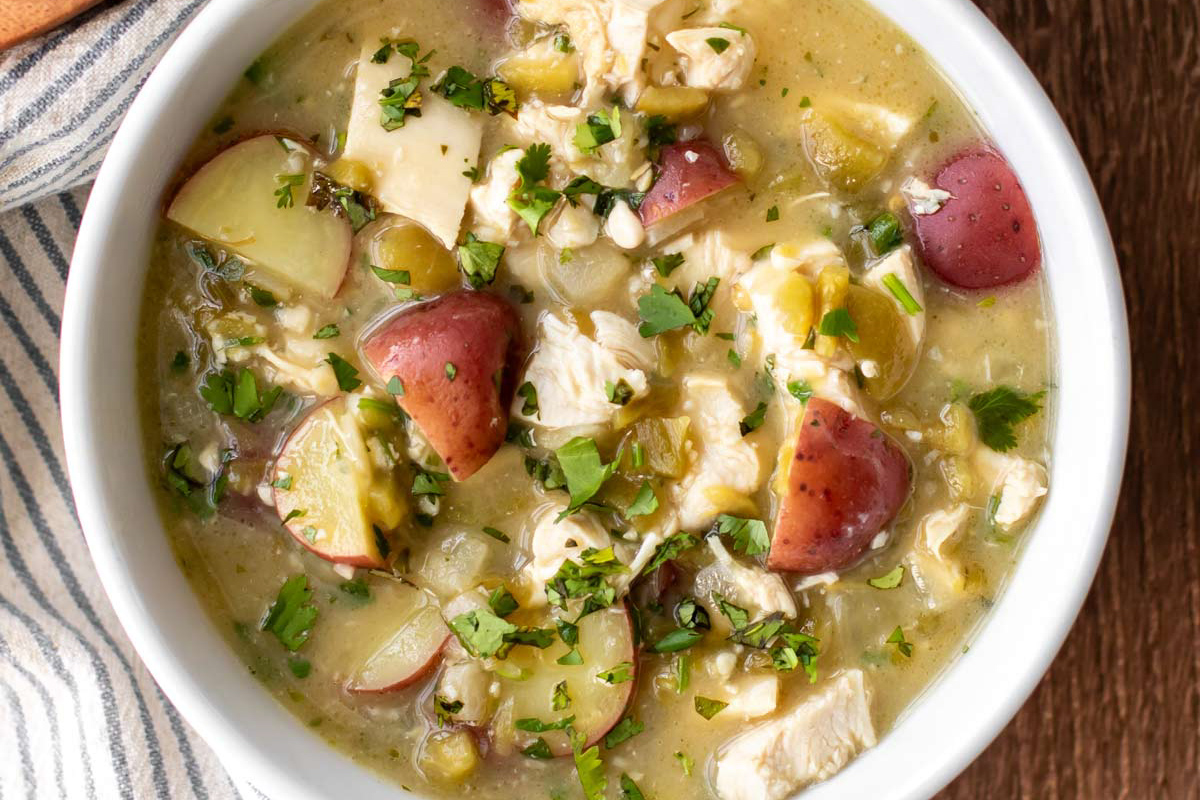 Green chile stew in a white bowl.