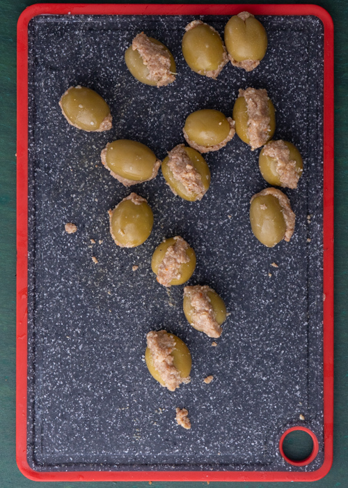 The meat in the olives on a cutting board.