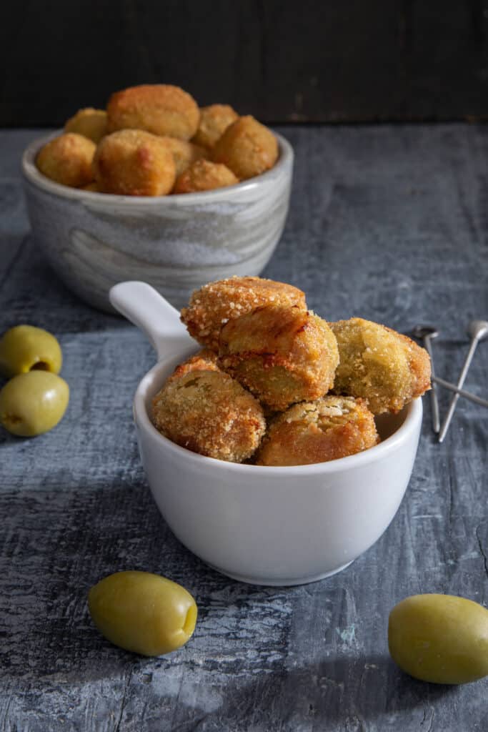 Olive ascolane in a grey bowl and two in a white bowl.