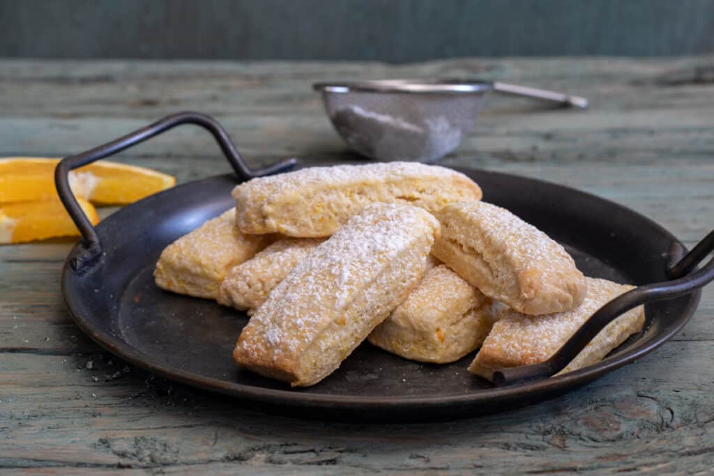 Dunking cookies on a black plate.